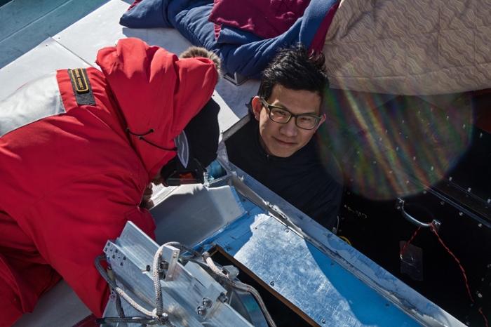 <strong>Getting their hands cold.</strong> Dan Marrone and Junhan Kim install a mirror on the roof of the South Pole Telescope in Antarctica. Courtesy Junhan Kim, University of Arizona.